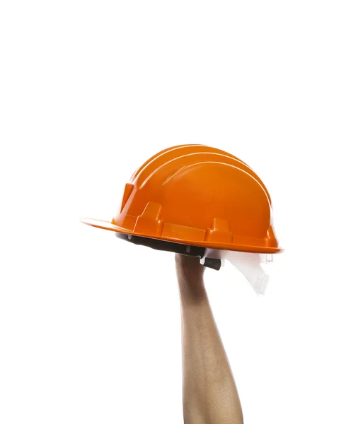 Mano masculina levantándose casco de seguridad naranja aislado en respaldo blanco — Foto de Stock