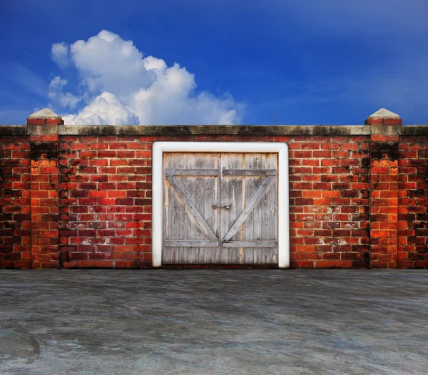 Corteccia porta del fienile di legno del pannello sul vecchio muro di mattoni con cielo blu behin — Foto Stock