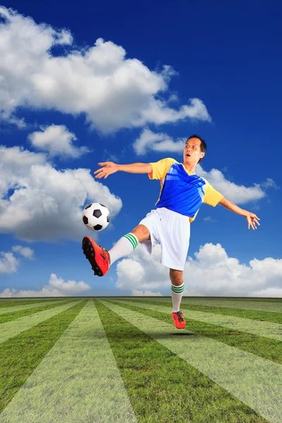緑の芝生の上に浮かぶ男性のサッカー選手とサッカー ボール — ストック写真