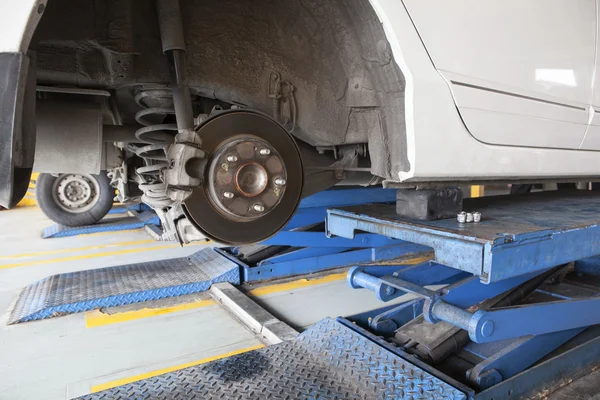 Mantenimiento de sedán coche suspensión amortiguador y freno cal — Foto de Stock