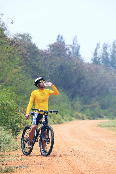 Young bicycle (cyclist) man drinking fresh water from plastic bo — Stock Photo, Image