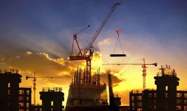 Gran grúa y construcción de edificios contra el hermoso cielo oscuro Fotos De Stock Sin Royalties Gratis