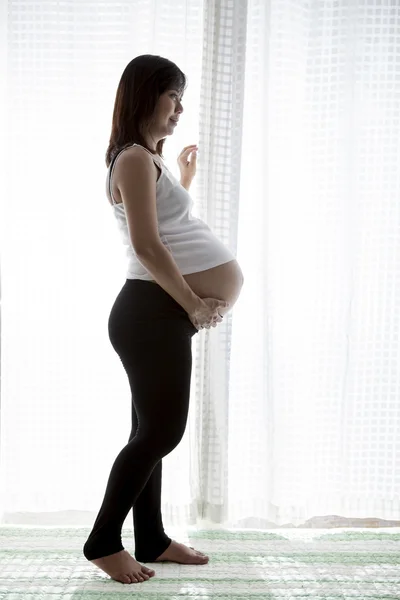 Asian woman pregnant ,pregnancy standing in home room against wh — Stock Photo, Image