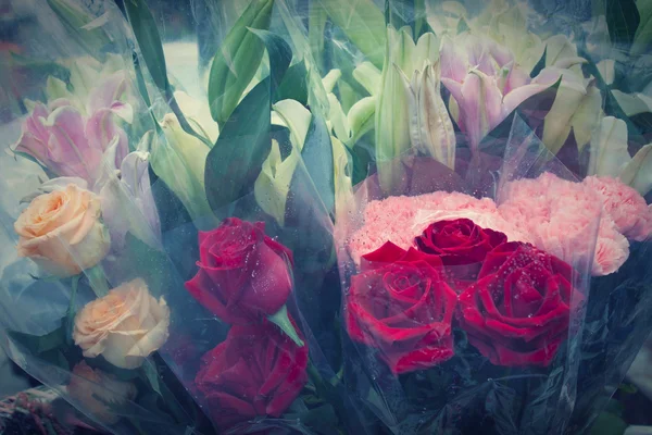 Ramo de flores de rosas rojas en plástico envuelto por pastel vintage colo — Foto de Stock