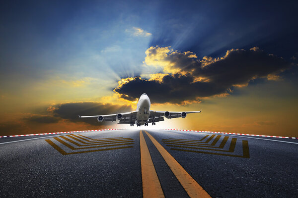 Big passenger plane flying over airport runway against beautiful