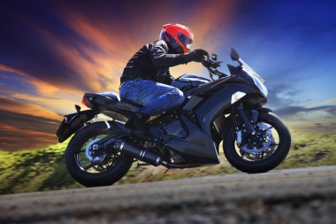 genç adam asfalt ülke road aga eğri üzerinde motosiklet sürme