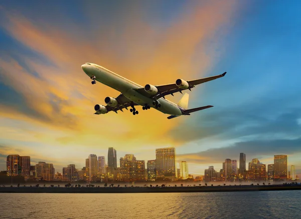 Passagierflugzeug fliegt über urbane Szenerie Nutzung für Komfortluft — Stockfoto