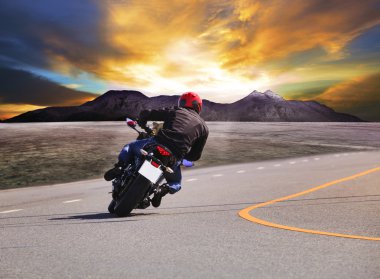 Dikiz genç adam asfalt yol eğrisindeki w motosiklet sürme