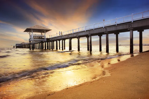 Schiffsanlegestelle mit Sonnenuntergang, dunkler Himmel am Meeresstrand — Stockfoto