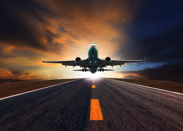 Passenger jet plane flying over airport runway against beautiful — Stock Photo, Image