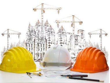 Safety helmet on engineer working table against sketching of building construction and high crane clipart