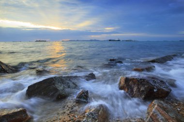 uzun explosure fotoğraf teknik üzerinde gökyüzü güzel gün batımı ile Rock deniz plaj