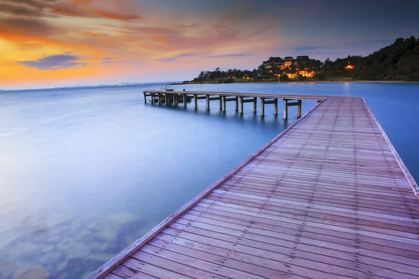 Wood bridge piers with nobody and smoothy sea water against beau — Stock Photo, Image