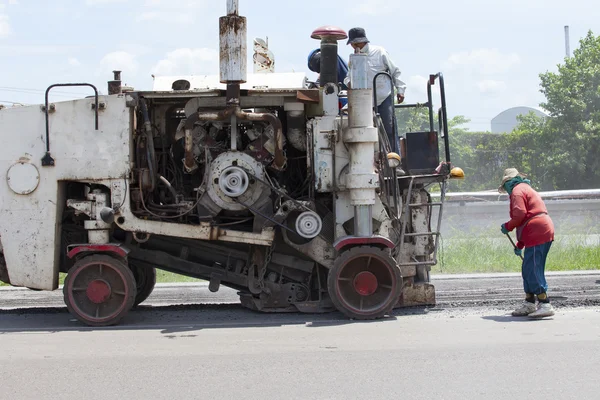 Arbetare och maskin arbetar på vägbyggen — Stockfoto