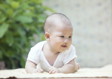 gülen bebek Teras evde yumuşak yatakta yatarken yüzünü kapat 