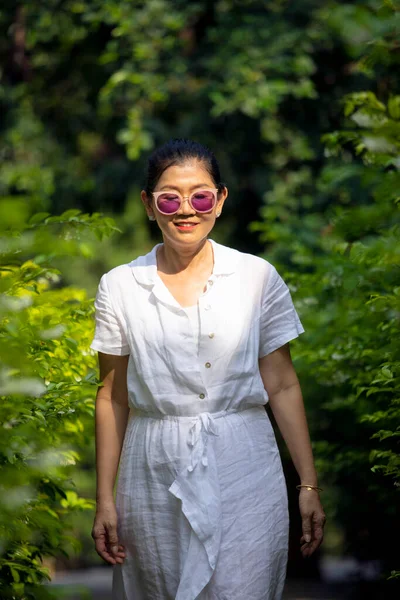 Yeşil Parkta Duran Beyaz Elbiseli Asyalı Kadın — Stok fotoğraf