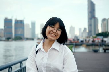 Asyalı dişlek mutlu yüzle gülümseyen, açık havada duran