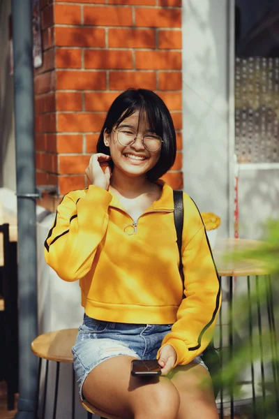 Azjatycki Nastolatek Smartfonem Ręku Siedzi Zewnątrz Stół Jadalny — Zdjęcie stockowe