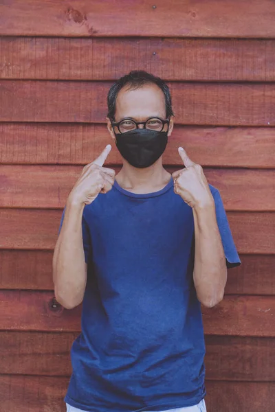 Aziatische Man Dragen Gezicht Bescherming Masker Staan Tegen Houten Muur — Stockfoto