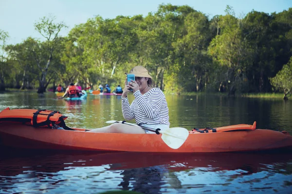 Yelkenli Kano Kullanırken Cep Telefonuyla Fotoğraf Çeken Genç Bir Kadın — Stok fotoğraf