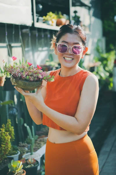 Piękna Kobieta Podnosząc Garnek Kwitnących Roślin Kwiatowych Twarzy Szczęścia — Zdjęcie stockowe