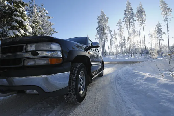 SUV, αυτοκίνητο οδήγησης μέσω ένα χειμερινό τοπίο — Φωτογραφία Αρχείου
