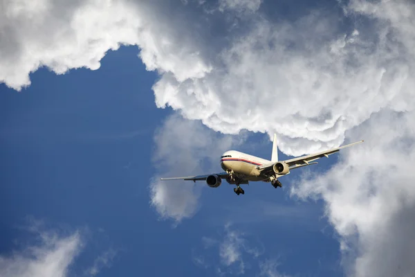 Vliegtuig vliegen door dramatische wolken — Stockfoto