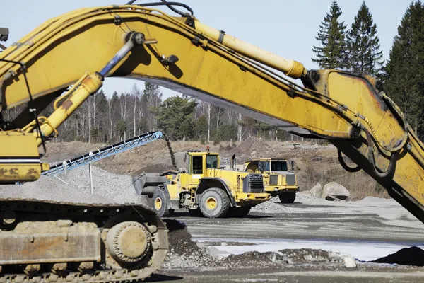 Bulldozers in action, dark clouds moving in — Stock Photo, Image