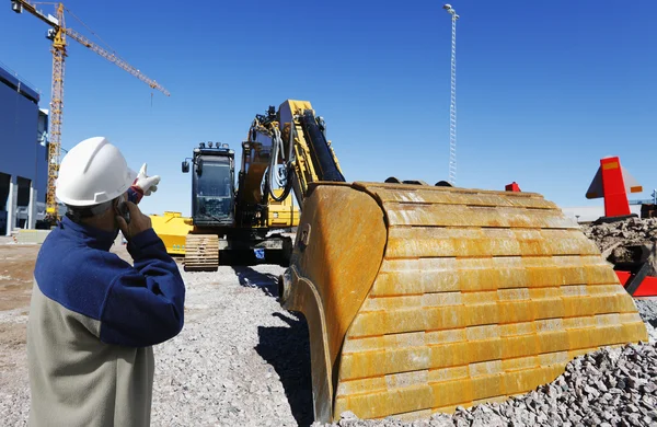 Engineer overlooking bulldozer — Stock Photo, Image