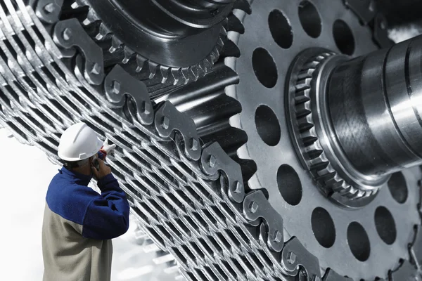 Gears and cogwheels operated by industry worker — Stock Photo, Image