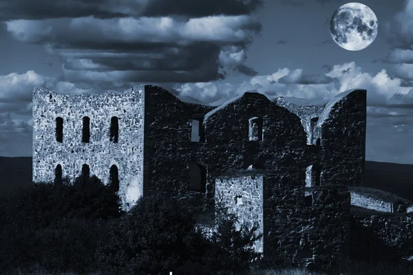 Vieja ruina abandonada del castillo bajo una luna llena — Foto de Stock
