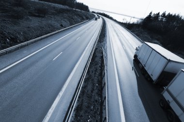 Truck driving on a dual lane freeway clipart