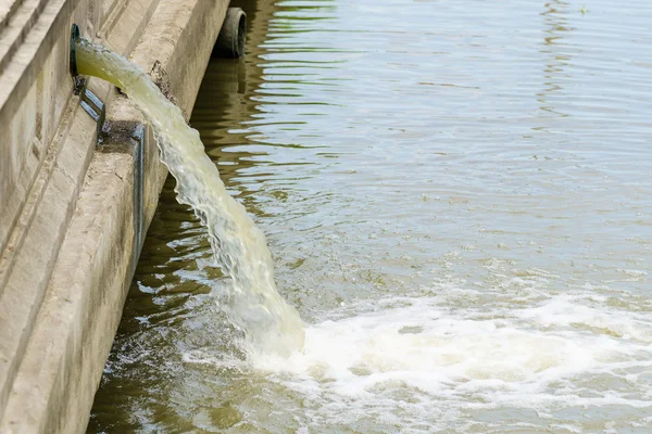 Flow out water from the conduit to the river — Stock Photo, Image