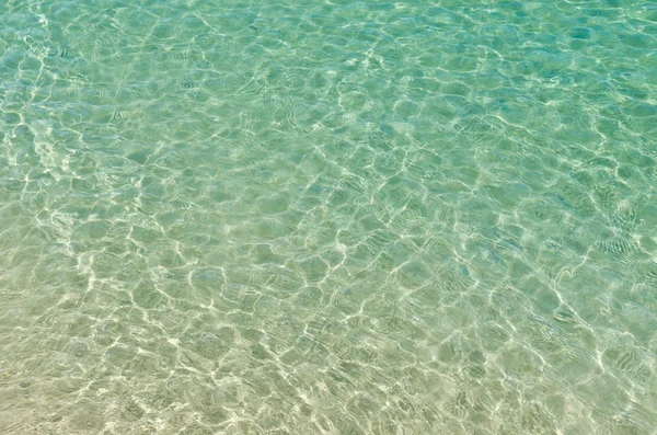 Klares Wasser am Strand, das sich in der Sonne spiegelt — Stockfoto