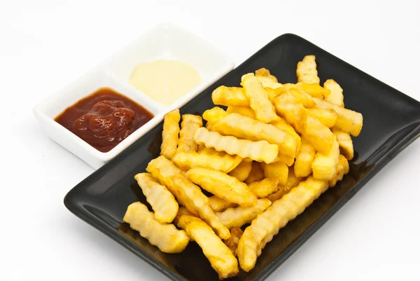 Batatas fritas em prato preto — Fotografia de Stock
