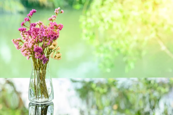 干粉色花朵装饰用花瓶放在桌子玻璃上 叶面反射模糊 — 图库照片