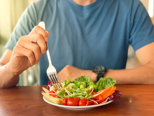 男の手は緑のサラダをスクープ 健康的なライフスタイルと菜食主義者のコンセプト 断続的な断食 — ストック写真