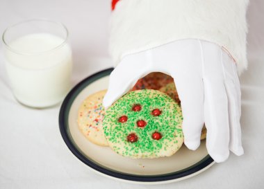 Santas Hand Reaching for Christmas Cookie clipart