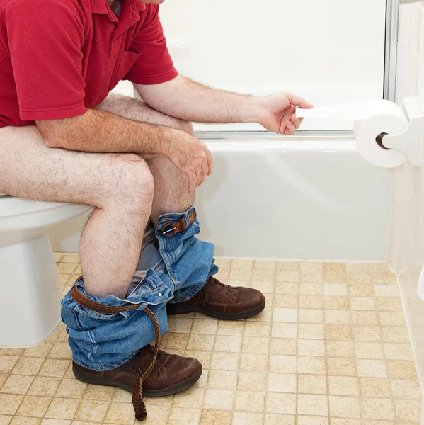 Hombre usando papel higiénico en el baño —  Fotos de Stock