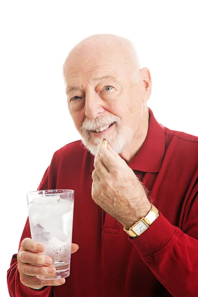 Starší muž s rybím tuku kapsle — Stock fotografie