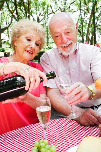 Senior picnic - gieten van champagne — Stockfoto