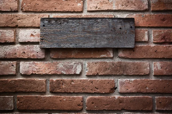 Houten teken op vintage bakstenen muur — Stockfoto