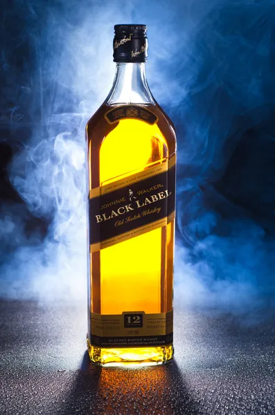 Johnnie Walker Whisky med røg på sort baggrund - Stock-foto