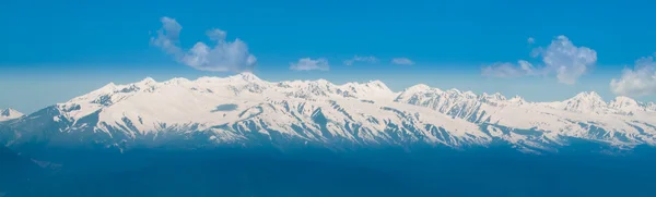 พาโนรามาของภูเขาหิมะ ภูมิทัศน์ที่มีท้องฟ้าสีฟ้า — ภาพถ่ายสต็อก