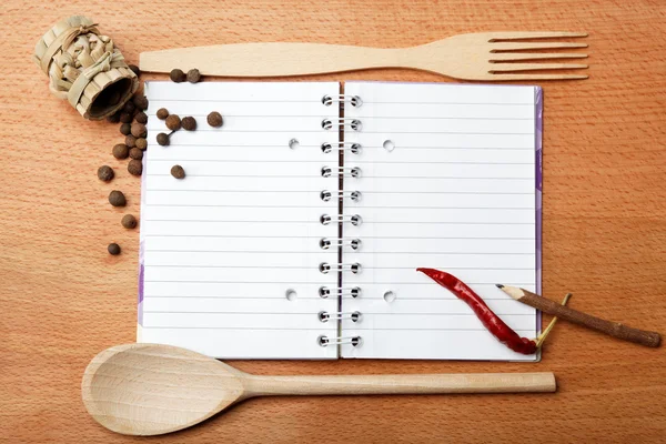 Cuaderno para recetas y especias en mesa de madera — Foto de Stock