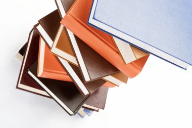 Beyaz arkaplanda bir yığın kitap.