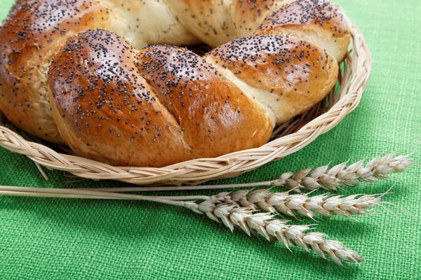 Pane fresco con spighe di grano su tela verde . — Foto Stock