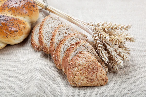 Pan fresco con espigas de trigo sobre el lienzo . —  Fotos de Stock
