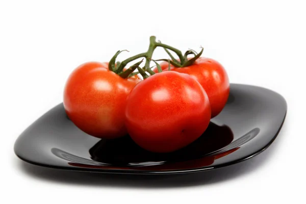 Frische Tomaten auf einem Teller, isoliert auf weißem Hintergrund. — Stockfoto
