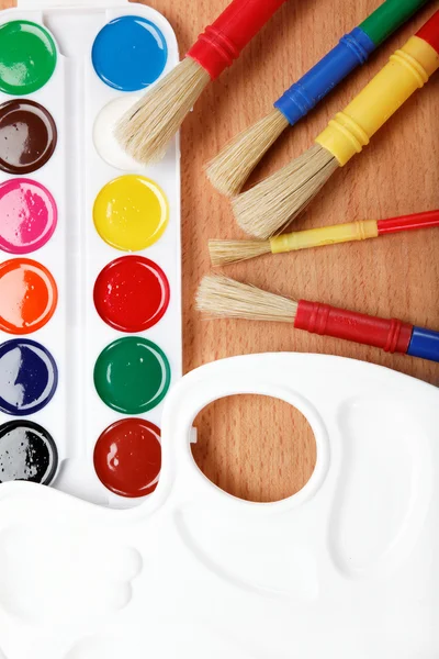Färg, paletten och penslar på ett träbord. — Stockfoto